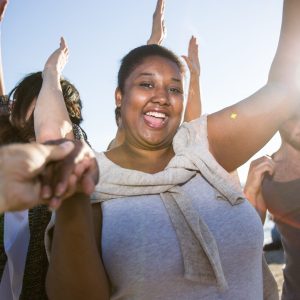 Ecstatic female dancing on the beach among her friends